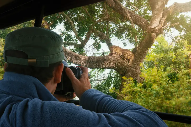 Photographer capturing wildlife from a safari jeep in Yala National Park, Sri Lanka
